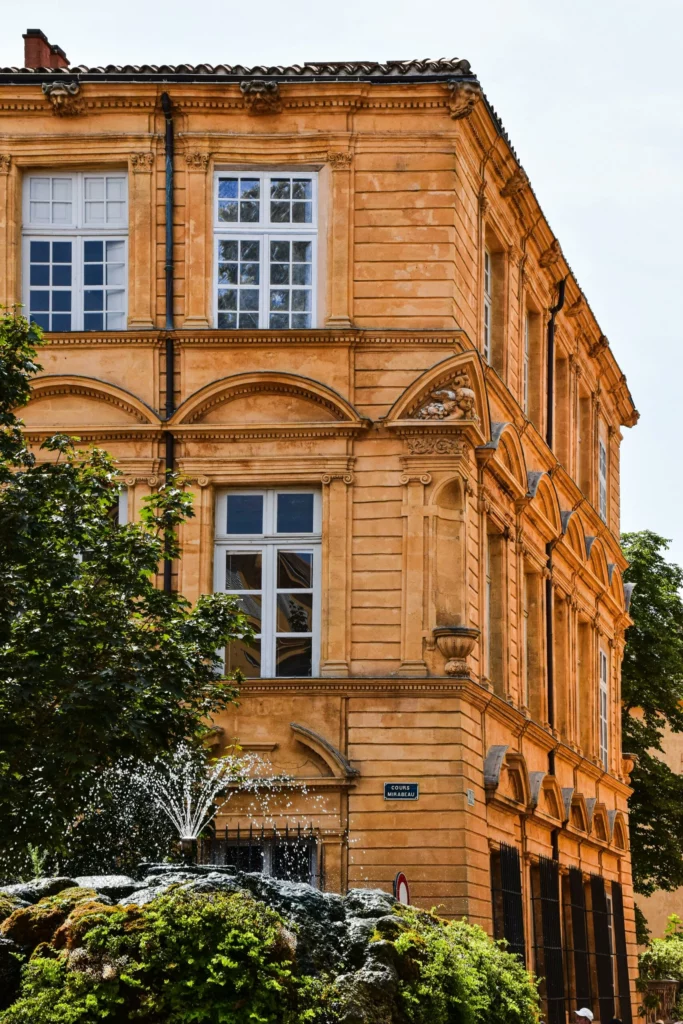 Architecture historique en pierre dorée du Luberon : façade de prestige et fontaine traditionnelle, illustrant l'expertise locale de Sanchez Expert Immobilier.
